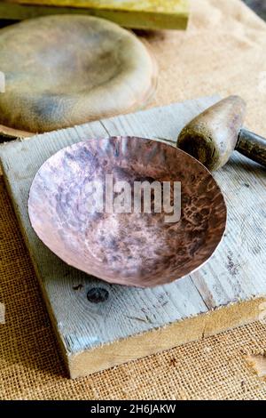 Kupferschale und Holzhammer, Kupferwerkstatt beim Medieval Festival Loxwood Joust, West Sussex, England, UK Stockfoto