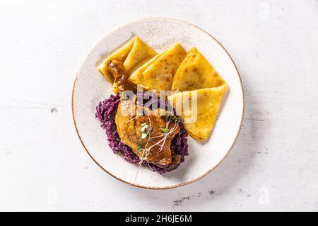 Portion Entenbein mit Rotkohl und Kartoffelpfannkuchen - Draufsicht. Stockfoto