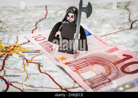 Der Tod des Euro - der grimmige Schnitter, der auf einer 10-Euro-Note auf einer Europakarte steht Stockfoto