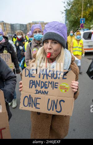 Greifswald, Deutschland. November 2021. Ein Mitarbeiter des Universitätsklinikums Greifswald (UMG) trägt bei einem Warnstreik in Greifswald ein Schild mit der Aufschrift „die nächste Pandemie dann ohne uns“. Der Streik ist eine Reaktion der Gewerkschaft auf die aktuellen Tarifverhandlungen für Beschäftigte im öffentlichen Dienst der Bundesländer. Quelle: Stefan Sauer/dpa/Alamy Live News Stockfoto