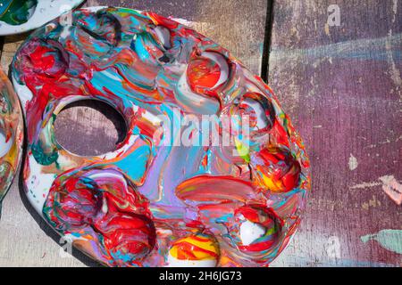 Farbpaletten, die mit mehrfarbigen Farben verschmiert sind. Stockfoto