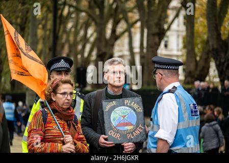 Polizei, die sich mit einem Protestierenden einlässt, der sich weigert, sich von der Straße zu bewegen, Rise and Rebel march, Extinction Rebellion, London, Großbritannien. November 2021 Stockfoto