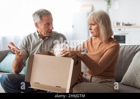 Unzufrieden Älteres Paar Auspacken Box Mit Beschädigten Waren Zu Hause Stockfoto