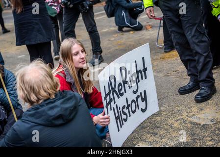 Frau mit ReRight-Hashtag auf der Straße sitzend, Rise and Rebel march, Extinction Rebellion, London, Großbritannien. November 2021 Stockfoto