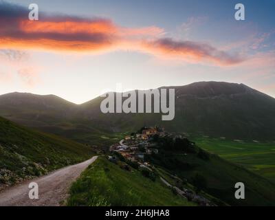 Blick auf das Dorf Castelluccio di Norcia mit Linsenfeldern und Bergen bei Sonnenaufgang, Perugia, Umbrien, Italien, Europa Stockfoto