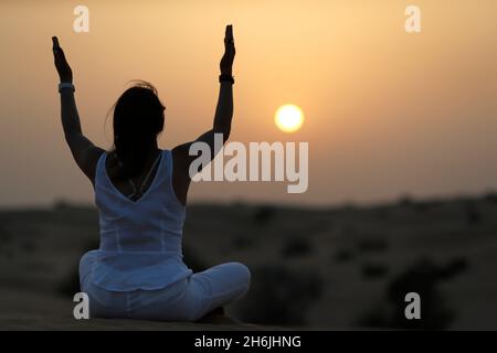 Sonnenuntergangsmeditation in der Wüste bei Sonnenuntergang, als Konzept für Religion, Glauben, Gebet und Spiritualität, Dubai, Vereinigte Arabische Emirate, Naher Osten Stockfoto