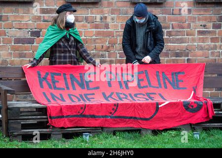 Greifswald, Deutschland. November 2021. Klimaaktivisten demonstrieren zu Beginn der Anhörung vor dem Gebäude des Obersten Verwaltungsgerichts (OVG) gegen die Klimapolitik von Nord Stream 2. Die OVG verhört eine Klage der Deutschen Umwelthilfe (DUH) gegen Nord Stream 2. DUH hatte im Sommer 2020 eine Klage wegen einer Überprüfung der Bau- und Betriebsgenehmigung für Nord Stream 2 durch die Bergbaubehörde Stralsund eingereicht. Quelle: Stefan Sauer/dpa/Alamy Live News Stockfoto
