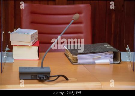 Greifswald, Deutschland. November 2021. Akten und Rechtsbücher liegen auf dem Richtertisch im Gerichtssaal des OVG Mecklenburg-Vorpommern. Die OVG verhört eine Klage der Deutschen Umwelthilfe (DUH) gegen Nord Stream 2. DUH reichte im Sommer 2020 eine Klage ein, um eine Überprüfung der Bau- und Betriebsgenehmigung für Nord Stream 2 durch die Bergbaubehörde Stralsund zu beantragen. Quelle: Stefan Sauer/dpa/Alamy Live News Stockfoto