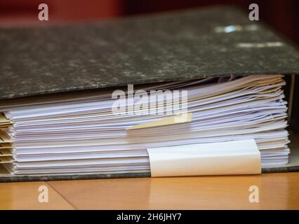 Greifswald, Deutschland. November 2021. Akten und Rechtsbücher liegen auf dem Richtertisch im Gerichtssaal des OVG Mecklenburg-Vorpommern. Die OVG verhört eine Klage der Deutschen Umwelthilfe (DUH) gegen Nord Stream 2. DUH reichte im Sommer 2020 eine Klage ein, um eine Überprüfung der Bau- und Betriebsgenehmigung für Nord Stream 2 durch die Bergbaubehörde Stralsund zu beantragen. Quelle: Stefan Sauer/dpa/Alamy Live News Stockfoto