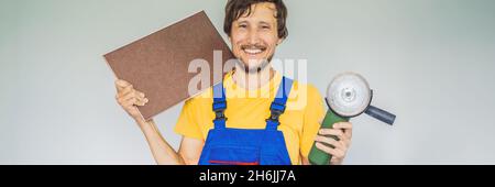 Ein Fliesenleger, ein Fliesenspezialist, hält einen Fliesenschneider in seinen Händen, EIN LANGFORMATIGES BANNER Stockfoto