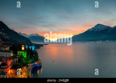 Weihnachtslichter schmücken den alten Glockenturm und die Häuser in Gravedona bei Sonnenaufgang, Comer See, Lombardei, Italienische Seen, Italien, Europa Stockfoto