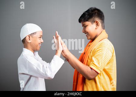 Happy Hindu muslim multiethnic Kids by playing by klating hands - Konzept zeigt Einheit, Vielfalt, Gemeinschaftsfreiheit und religiöse Harmonie Stockfoto