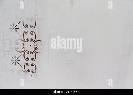 Nahaufnahme der Wand während des Putzprozesses, wobei die Vintage-Fliesen mit goldenen und schwarzen Details bedeckt sind. Stockfoto