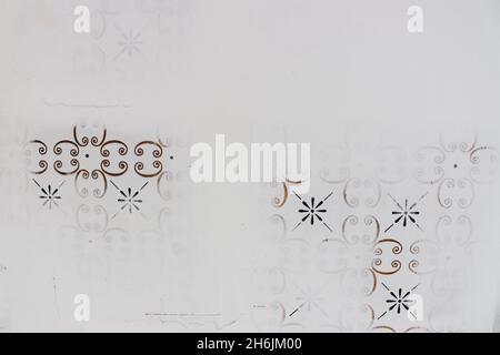 Nahaufnahme der Wand während des Putzprozesses, wobei die Vintage-Fliesen mit goldenen und schwarzen Details bedeckt sind. Stockfoto