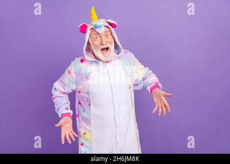 Porträt von attraktiven fröhlich erstaunt grauhaarigen Mann trägt Kigurumi Spaß isoliert über violett lila Farbe Hintergrund Stockfoto