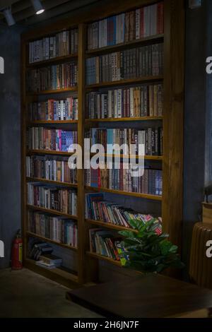 Holzregale mit Büchern im Café. Vintage-Stil in einem Café. Bibliothek. Hochwertige Fotos Stockfoto