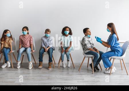 Krankenschwester, die PCR-Test für Jungen Testing Kinder Gruppe Indoor Stockfoto