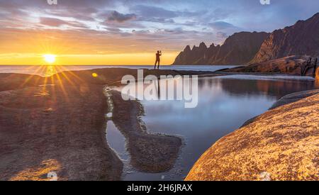 Mann im Hintergrund Sonnenuntergang fotografieren die Berggipfel mit Smartphone, Tungeneset, Senja, Troms County, Norwegen, Skandinavien, Europa Stockfoto