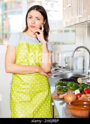 Traurige junge Mädchen Hausfrau in Schürze zu Hause Küche Stockfoto