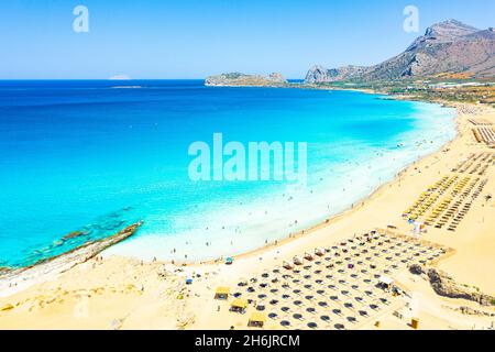 Sonnenschirme und Sonnenliegen am weißen Sandstrand von Falassarna mit Blick auf das kristallklare Meer, Kissamos, Chania, Kreta, griechische Inseln, Griechenland, Europa Stockfoto