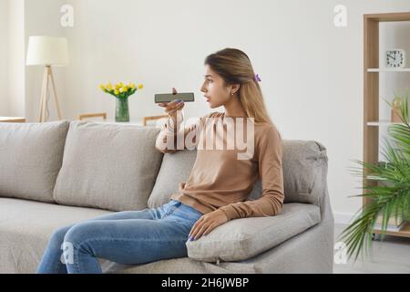 Teenager-Mädchen spricht mit dem Mobiltelefon über digitale Sprachanwendung, um im Internet zu suchen. Stockfoto