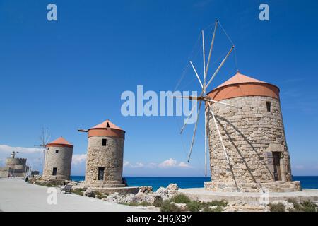 Windmühlen von Mandraki, Fort von St. Nikolaus im Hintergrund, Mandraki Hafen, Rhodos, Dodekanes Inselgruppe, Griechische Inseln, Griechenland, Europa Stockfoto