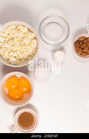 Backzutaten auf einem weißen Tisch. Weiße Eier, Mehl, Zucker und Gewürze. Home Konzept zum Backen, Backen von Kuchen oder Keksen. Draufsicht. Flach Stockfoto