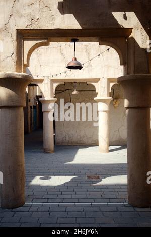 Das Alte Dubai. Traditionelle arabische Straßen im historischen Viertel Al Fahidi, Al Bastakiya. Dubai, Vereinigte Arabische Emirate. Heller, sonniger Nachmittag in einer Steinstraße in einer traditionellen orientalischen Stadt. Stockfoto