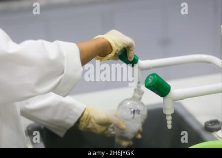 Nahaufnahme der Hand einer Wissenschaftlerin beim Waschen von Geräten nach einem Experiment im Labor Stockfoto