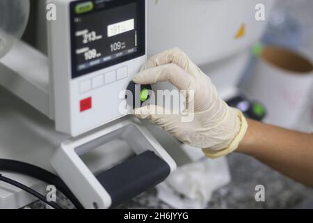 Nahaufnahme einer Hand einer Wissenschaftlerin, die einen Rotationsverdampfer bediente, um ein Experiment im Labor zu machen Stockfoto