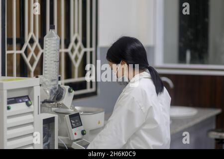 Asiatische Wissenschaftlerin, die einen Rotationsverdampfer bediente, um im Labor ein Experiment zu machen Stockfoto