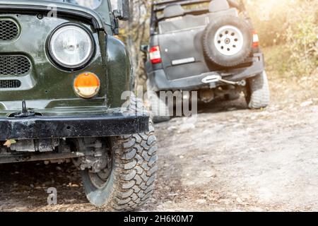 Paar von zwei alten Retro-Oldtimer 4x4 sowjetischen suv-Fahrzeug auf Schotter unbefestigten Straße im Sommer bei Sonnenuntergang Morgensonne. Geländewagen-Bergsafari Stockfoto