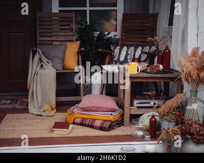 Herbst hölzerne Veranda oder Terrasse, Familienerbstücke, mit Kürbissen und gemütlichen Decken. thanksgiving Landschaftsgestaltung. Stockfoto