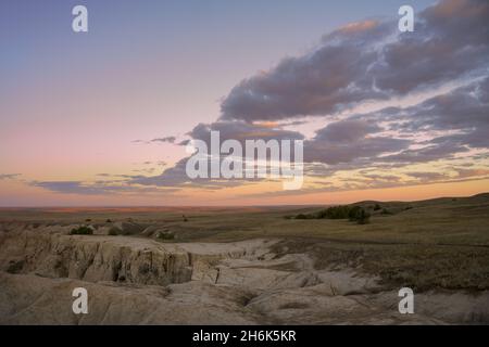 Die Badlands treffen bei Sonnenaufgang auf die Hochebenen von South Dakota im Badlands National Park von South Dakota Stockfoto