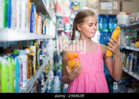 Lächelnd teen Mädchen suchen Spray von Sonnenschutz Stockfoto