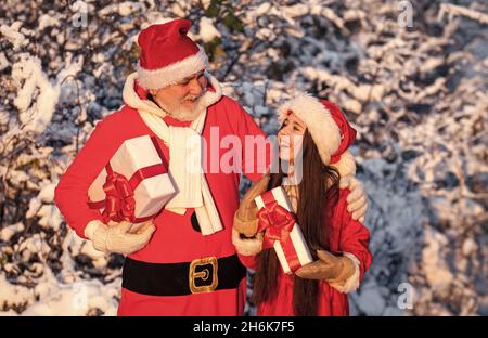 Geschenke vom Weihnachtsmann. Frostiger weihnachtsmorgen. Santa und Enkelin. Zeit für Wunder. Großzügiger Weihnachtsmann. Kind glücklich Mädchen im Freien verschneite Natur Stockfoto