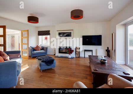 Essex, England - November 18 2019: Wohnzimmer innerhalb des britischen Hauses mit Holzboden und modernen Möbeln inklusive bunten Kissen Stockfoto