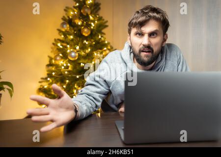 In der Nacht im Büro sitzt am Silvesterabend ein Mann vor einem Computer Stockfoto