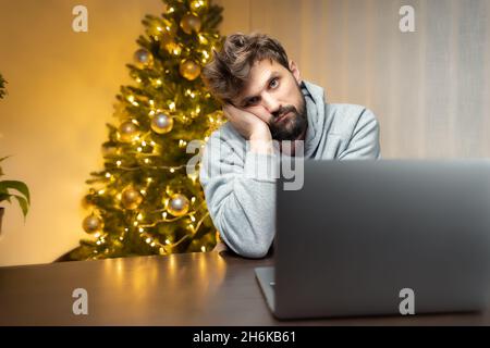 In der Nacht im Büro sitzt am Silvesterabend ein Mann vor einem Computer Stockfoto