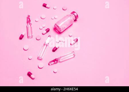 Impfstoff und Spritze, verschiedene pharmazeutische Pillen, Tabletten und Kapseln auf blauem Hintergrund. Gesundheitswesen und medizinisches Konzept. Stockfoto