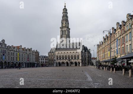 Arras, Frankreich - 4. November 2021: Marktplatz von Arras, Frankreich. Der Belfried von Arras, das zum UNESCO-Weltkulturerbe gehört, steht vor einem dunkelgrauen Himmel Stockfoto