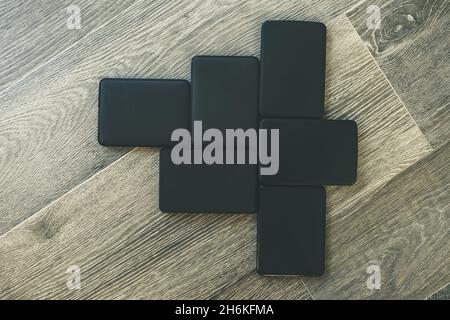 Viele tragbare Festplatten auf dem Holzboden. Mosaik von usb-Speichergeräten. Externe Computergeräte. Cloud-Technologie, Online-Festplatte, Remote-Back-U Stockfoto