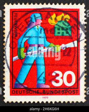 DEUTSCHLAND - UM 1970: Eine in Deutschland gedruckte Briefmarke zeigt Feuerwehrmann, der verschiedene Freiwilligendienste ehrt, um 1970 Stockfoto