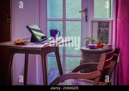Notebook neben Gebäck, Stift und einer Tasse Kaffee auf einem Holztisch - Work from Home Konzept Stockfoto