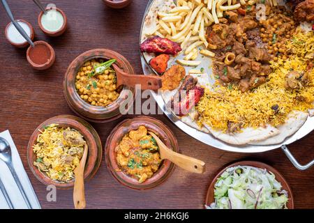 Sheffield UK – 11. Mai 2018: Afghanisches Chicken- und Kichererbsenurrfleisch, Pilau-Reis und ein Hammelurrfleisch sowie eine Tikka-Chicken-Sharing-Platte Stockfoto