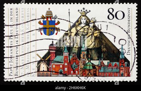 DEUTSCHLAND - UM 1987: Eine in Deutschland gedruckte Briefmarke zeigt Papstwappen, Madonna mit Kind und Gebäude in Kevelaer, Staatsbesuch von Papst Johannes Paul II., Stockfoto