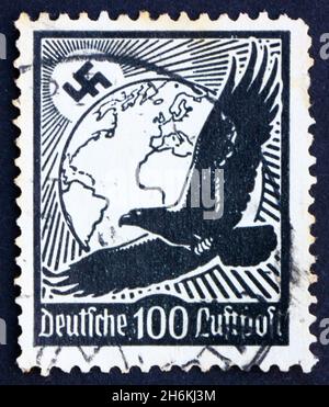 DEUTSCHLAND - UM 1934: Eine in Deutschland gedruckte Marke zeigt Swastika Sun, Globe und Eagle, um 1934 Stockfoto