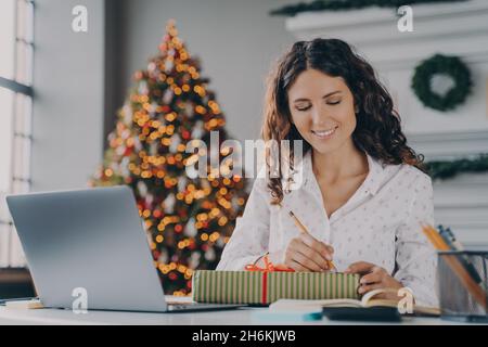 Junge schöne glückliche italienische Geschäftsfrau Zeichen vorbereitet Weihnachten Geschenk-Box für Kunden im Büro Stockfoto