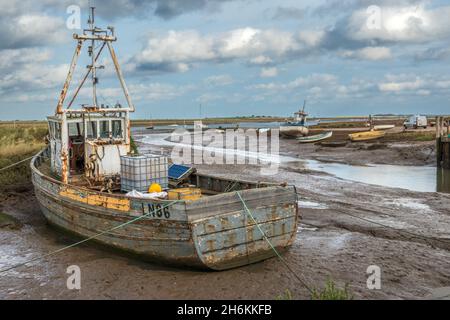 Altes Fischerboot bei Ebbe auf Grund in Brancaster Staithe Harbour North Norfolk England Stockfoto
