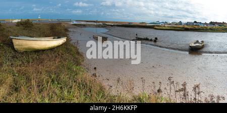 Ebbe mit Booten im Schlamm am Mow Creek Brancaster Staithe Harbour North Norfolk England Stockfoto